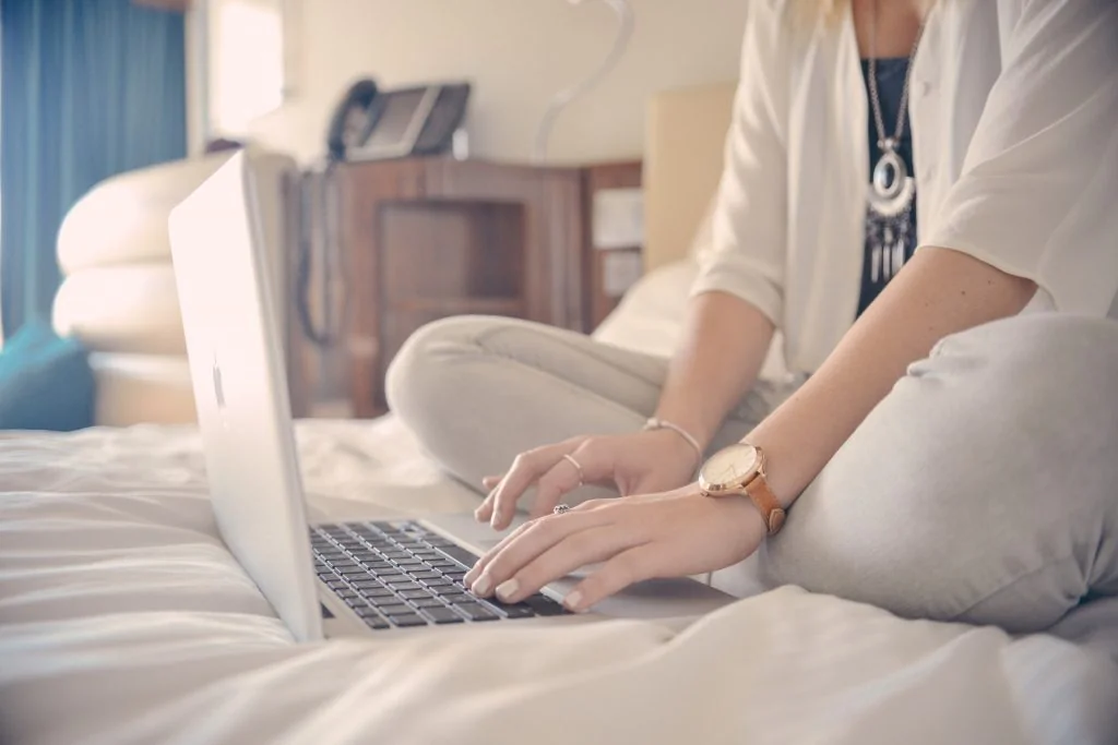 working on a laptop in bed