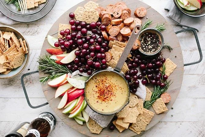 A seasonal charcuterie board filled with berries, fruit, crackers, and cheese