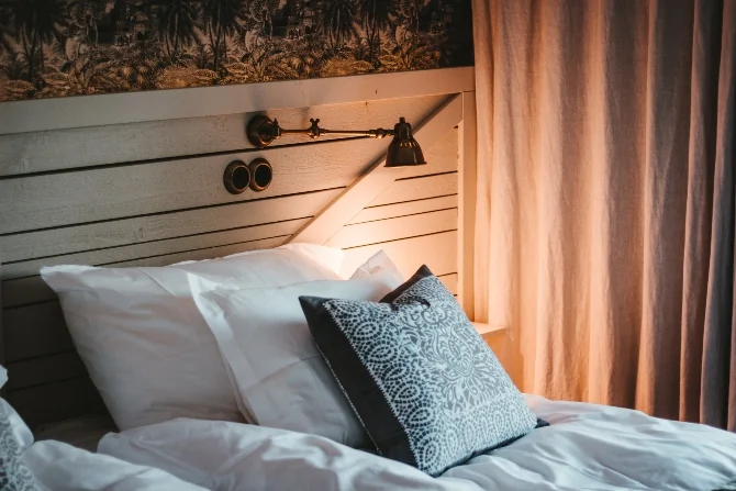A cosy bedroom gently lit by a lamp