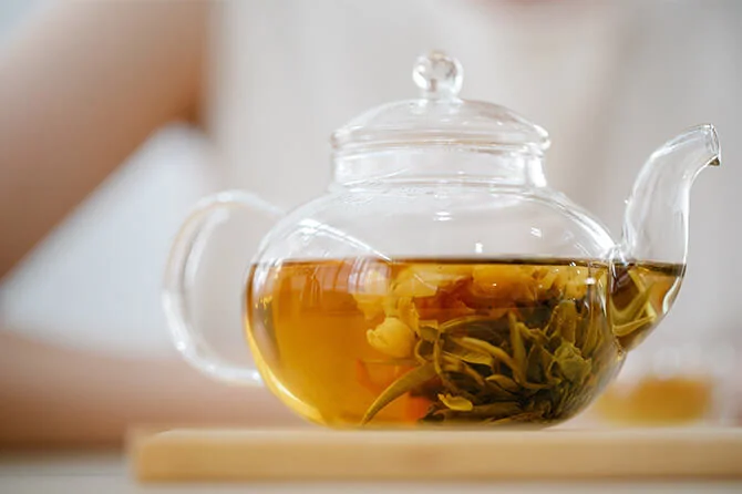 a pot of herbal tea and a full glass cup