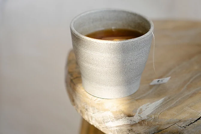Tea in a cup resting on a wooden table