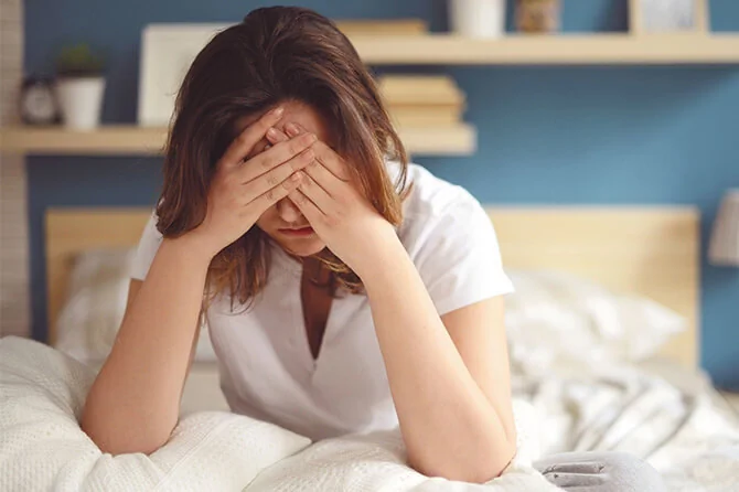 Exhausted women sat on her bed