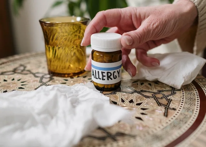 someone reaching for the allergy tablets