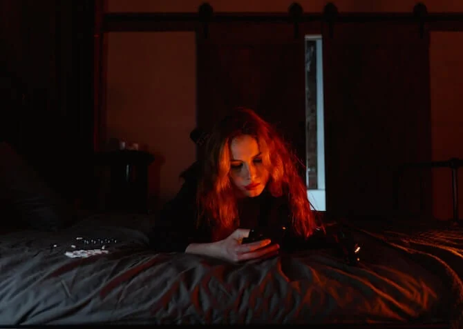 teenage girl in bed texting at night