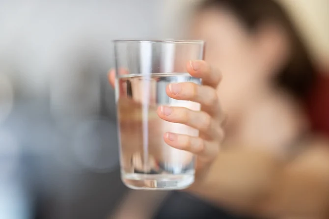 Woman holding glass of water
