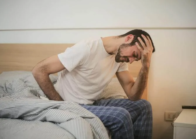 man in bed with a headache