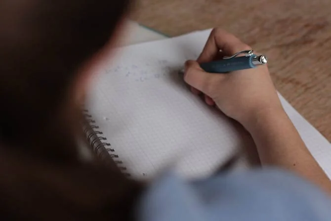 student making notes in note book