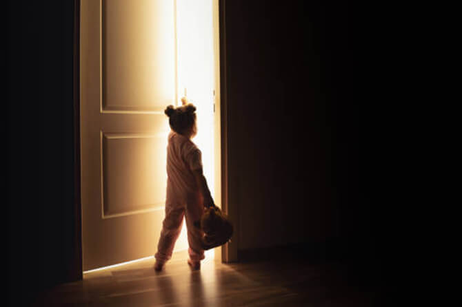 Ghostly child standing in bedroom doorway