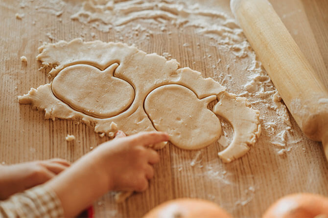 Rolled-out dough with pumpkin-shaped cookie cutters