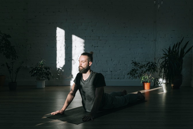 Man on yoga mat, stretching