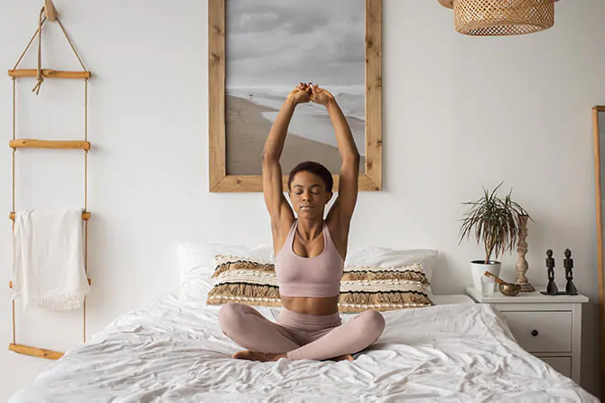 Woman doing yoga on a bed