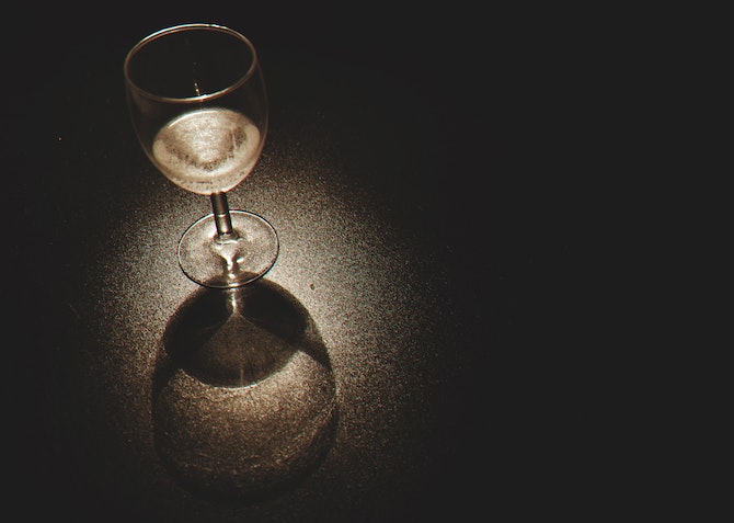 glass of white wine in the dark
