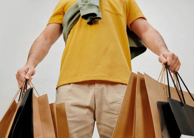 man with his hands full of black Friday shopping bags