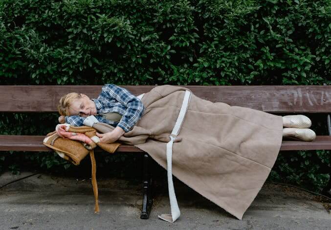 person sleep on a park bench