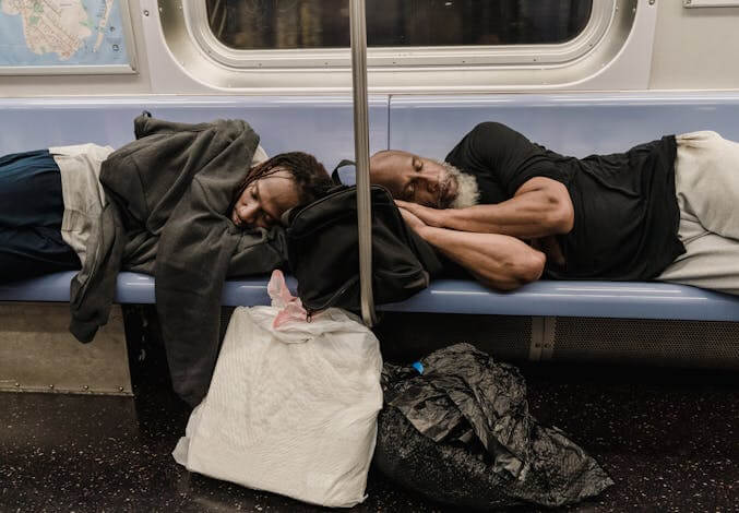 two people napping on the subway