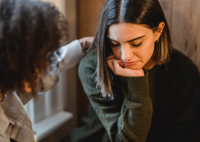 a stressed woman being supported by a friend