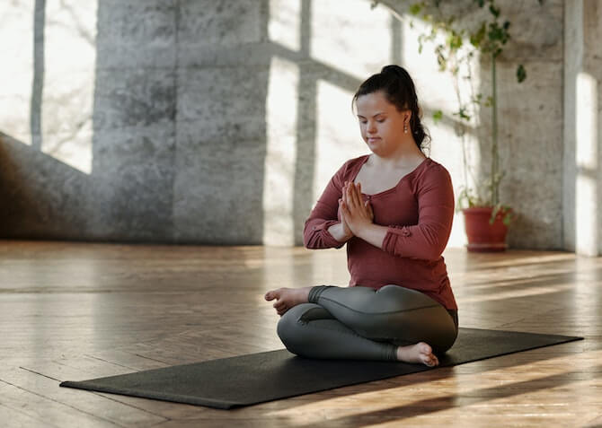 woman meditating in a large room alone