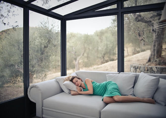 woman napping on a sofa in a conservatory