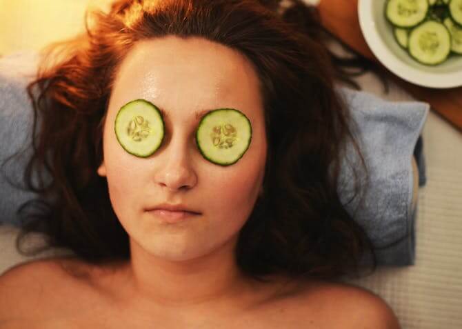 a woman with cucumber slices on her eyes for self-care