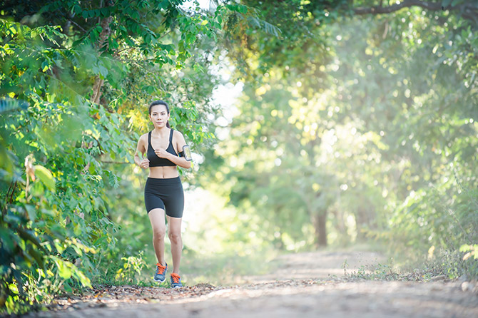 Woman running in park on sunny afternoon